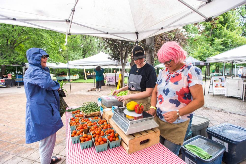 MIKAELA MACKENZIE / WINNIPEG FREE PRESS
Lilian Bonin (left) buys peppers and other fresh veggies from Celine Daignault (centre) and Michelle Boulet at Jonathan’s Farms, whose owner Jonathan Stevens is the founder of the Wolseley Farmers Market.