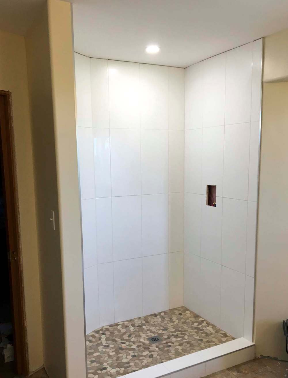 Marc LaBossiere / Winnipeg Free Press
The shower stall is first fully tiled, preserving the water feed access hole before the shower column is installed.
