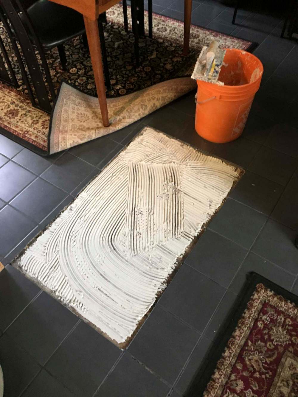 A premium-grade adhesive (above) was pre-mixed on site and trowelled into both areas before each tile was positioned. Two rows of tiles (below) were installed using rubber spacers to eliminate any shifting while the tile adhesive set.