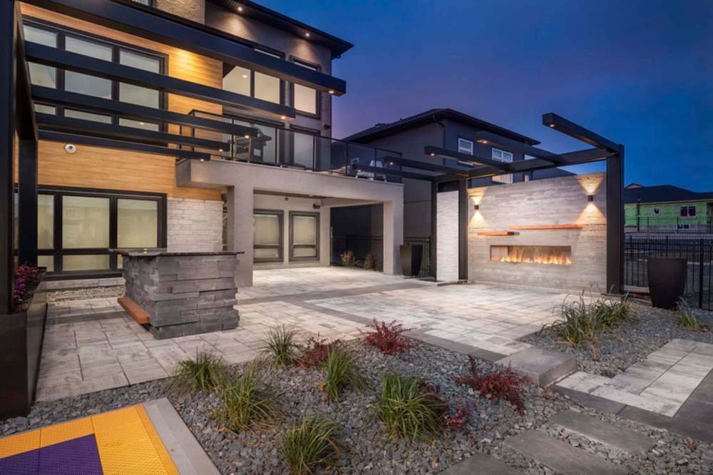 This entertainment area features an outdoor bar and a board form wall complete with gas fireplace and a vertical water feature.