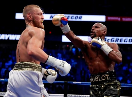 Isaac Brekken / The Associated PressFloyd Mayweather Jr. hits Conor McGregor in a super welterweight boxing match Saturday.