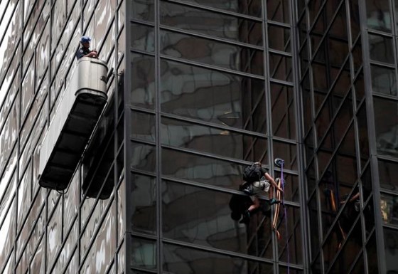 Associated PressA New York Police officer watches as a man attempts to scale Trump Tower.