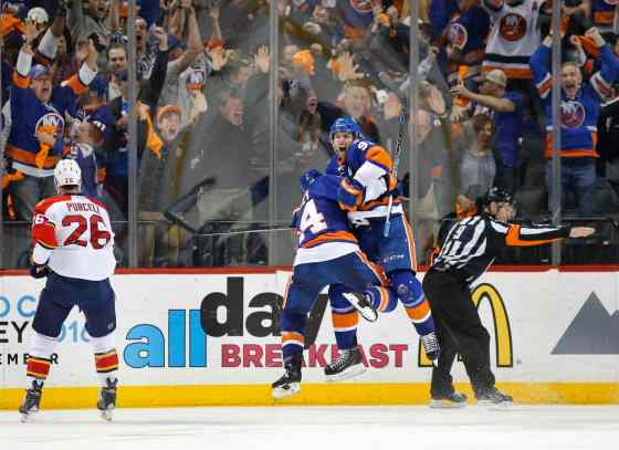 CPFlorida Panthers right wing Teddy Purcell (26) skates away as New York Islanders defenseman Thomas Hickey (14) celebrates with New York Islanders center John Tavares (91) after Tavares scored the winning goal in the second overtime period of Game 6 of an NHL hockey first-round Stanley Cup playoff series against the Florida Panthers in New York, Sunday, April 24, 2016. The Islanders defeated the 2-1. (AP Photo/Kathy Willens)