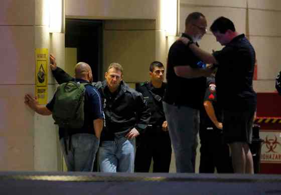 Tony Gutierrez / The Associated PressLaw enforcement officials wait outside the emergency room entrance at Baylor University Medical Center, Friday, in Dallas. Snipers opened fire on police officers in the heart of Dallas on Thursday night, killing some of the officers.