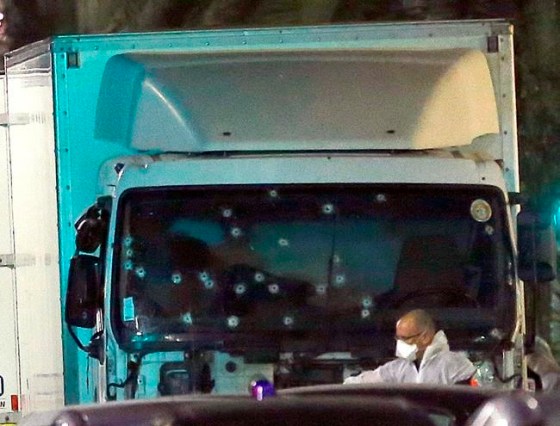 Claude Paris / THE ASSOCIATED PRESSA forensic officer stands near a van with its windscreen riddled with bullets, that plowed through a crowd of revelers who'd gathered to watch the fireworks in the French resort city of Nice, southern France, Friday.