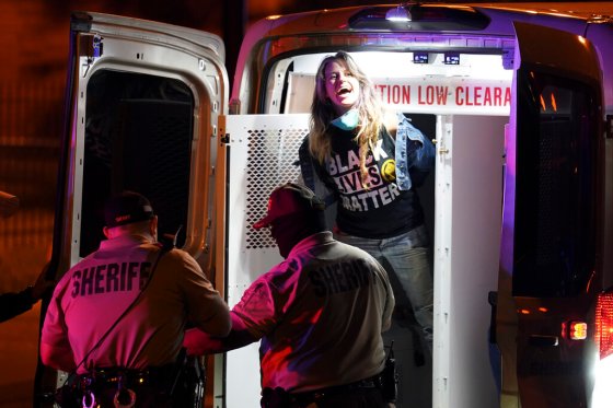 John Minchillo / The Associated PressA woman shouts after being detained by police after a curfew, Thursday, Sept. 24, 2020, in Louisville, Ky.