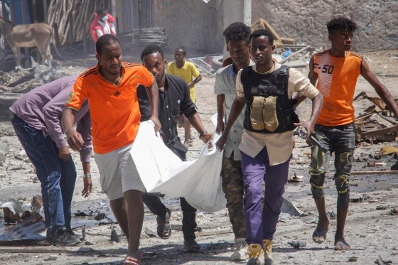 CPRescuers carry the body of a person killed in the blast. (Farah Abdi Warsameh / The Associated Press)
