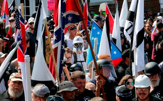 Steve Helber / The Associated PressWhite nationalist demonstrators walk into the entrance of Lee Park surrounded by counter demonstrators in Charlottesville, Va., Saturday.