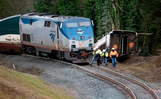 Elaine Thompson / The Associated PressWorkers walk over tracks near a curve at the back of where an Amtrak train derailed on Monday, in DuPont, Wash.
