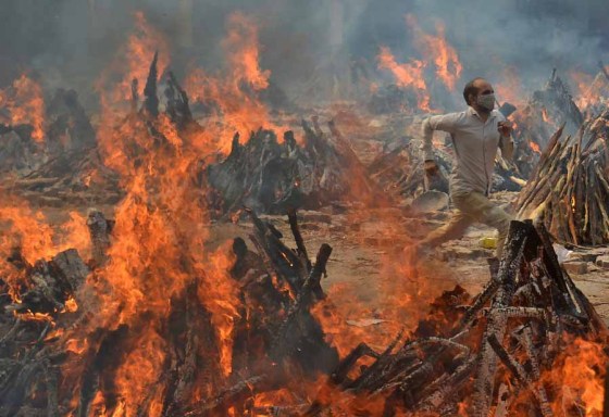 Amit Sharma / The Associated PressA man runs to escape the heat from funeral pyres of COVID-19 victims at a crematorium on the outskirts of New Delhi, India, last year. (Amit Sharma / The Associated Press files)