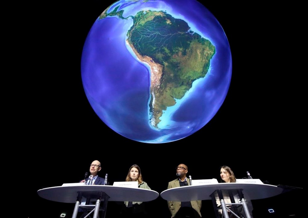FILE - Niklas Hoehne, from left, New Climate Institute Cologne, Luisa Neubauer, Fridays for Future activist, Peter Donatus, journalist and activist, and Linda Kastrop, activist, stand in front of a giant globe in the exhibition