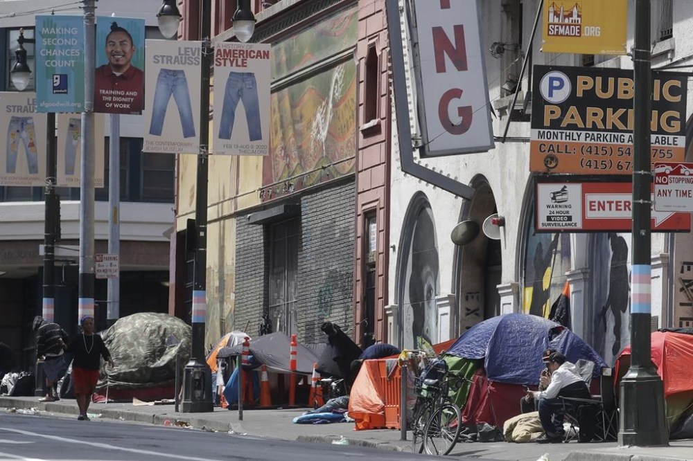 FILE - Tents line a sidewalk in the Tenderloin neighborhood of San Francisco on April 18, 2020. A federal judge ruled Wednesday, Aug. 10, 2022, that the pharmacy chain Walgreens can be held responsible for contributing to San Francisco's opioid crisis for over-dispensing opioids for years without proper oversight and failing to identify and report suspicious orders as required by law. Mayor London Breed declared a state of emergency last year in the Tenderloin, saying something had to be done about the high concentration of drug dealers and people consuming drugs out in public. (AP Photo/Jeff Chiu, File)