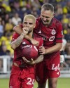 Toronto FC's Lorenzo Insigne (24) holds the ball under his shirt and sucks his thumb as he celebrates with Domenico Criscito (44) after Insigne scored a goal against Nashville SC during the second half of an MLS soccer match in Nashville, Tenn., Saturday, Aug. 6, 2022. Toronto FC's new high-flying offence and somewhat improved defence gets a test Saturday in the form of the visiting Portland Timbers. THE CANADIAN PRESS/AP Photo-Mark Humphrey