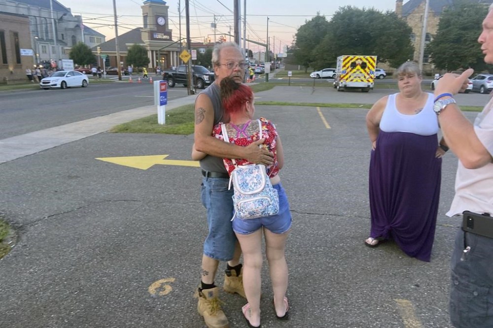 Nescopeck Volunteer Fire Company firefighter Harold Baker is comforted at the scene in Berwick, Pa., Saturday, Aug. 13, 2022, after authorities said a vehicle struck a crowd gathered at a bar to raise money for victims of a house fire that killed 10 earlier in the month. (Bob Kalinowski/The Citizens' Voice via AP)