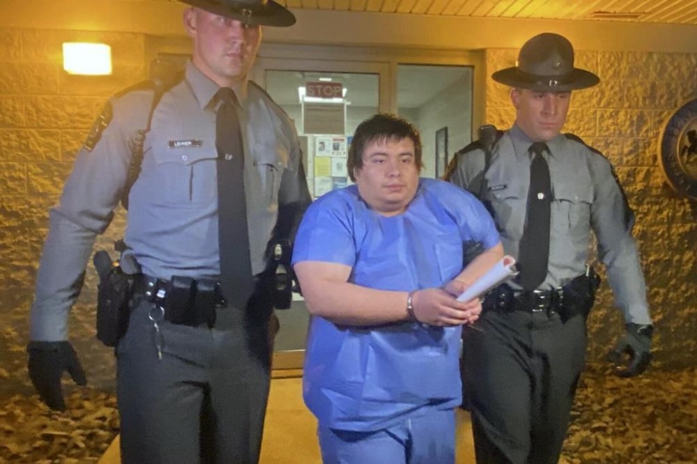 Adrian Oswaldo Sura Reyes, 24, of Nescopeck, Pa., is led from the state police barracks at Shickshinny, Pa., early Sunday morning, Aug. 14, 2022. Authorities said his vehicle struck a crowd gathered at a bar to raise money for victims of a house fire that killed 10 earlier in the month. (Bob Kalinowski/The Citizens' Voice via AP)