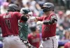 Arizona Diamondbacks' Ketel Marte, left, congratulates Christian Walker, right, who crosses home plate after hitting a three-run home run off Colorado Rockies starting pitcher Ryan Feltner in the third inning of a baseball game Sunday, Aug. 14, 2022, in Denver. (AP Photo/David Zalubowski)