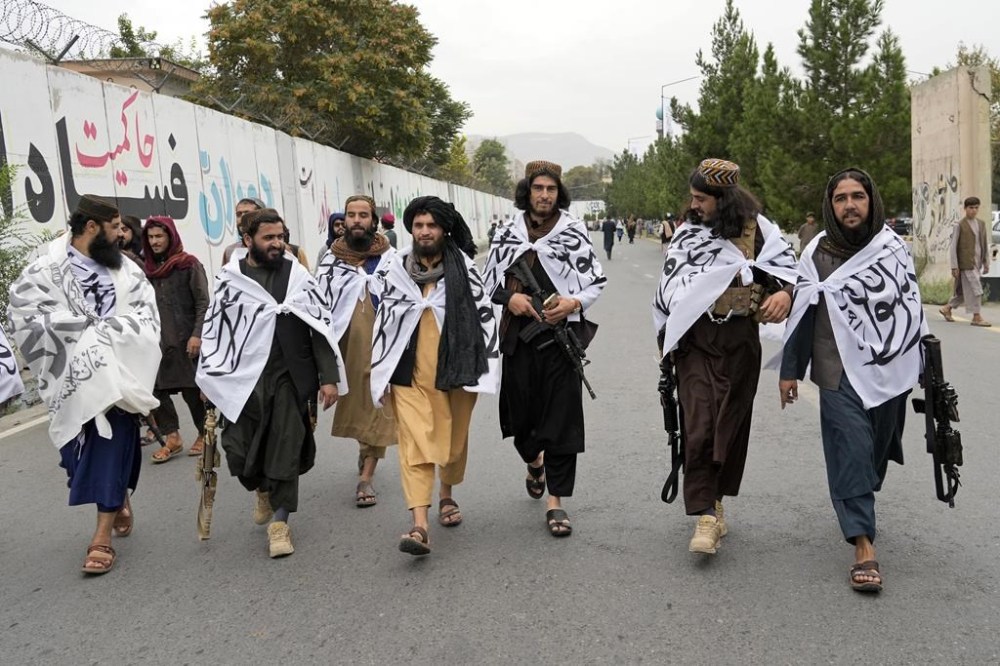 Taliban fighters celebrate one year since they seized the Afghan capital, Kabul, in front of the U.S. Embassy in Kabul, Afghanistan, Monday, Aug. 15, 2022. The Taliban marked the first-year anniversary of their takeover after the country's western-backed government fled and the Afghan military crumbled in the face of the insurgents' advance. (AP Photo/Ebrahim Noroozi)