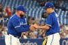 Toronto Blue Jays starting pitcher Yusei Kikuchi, left, is taken out of the game by manager John Schneider in the fourth inning American League baseball action against the Baltimore Orioles in Toronto on Monday, August 15, 2022. THE CANADIAN PRESS/Jon Blacker