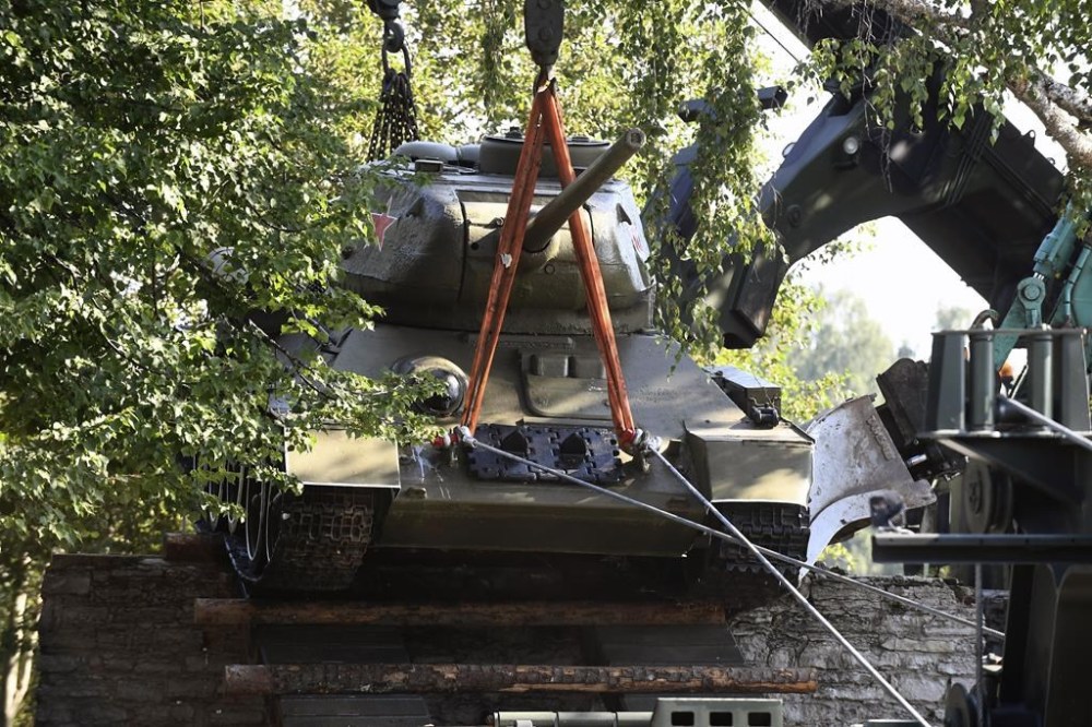 Workers remove a Soviet T-34 tank installed as a monument in Narva, Estonia, Tuesday, Aug. 16, 2022. Estonia's government said Tuesday it has decided to remove a Soviet monument in a border town sitting in the Baltic country's Russian-speaking part, with the prime minister saying the reason for the dismantling is that it represents a risk for public order. (AP Photo/Sergei Stepanov)