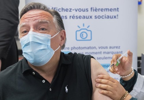 Quebec Premier François Legault receives a COVID-19 booster vaccine dose from Kenza Kias in Montreal on Aug. 5, 2022. Quebec is launching a massive COVID-19 booster vaccine campaign as health officials expect cases to go up in the fall with students returning to school. THE CANADIAN PRESS/Graham Hughes