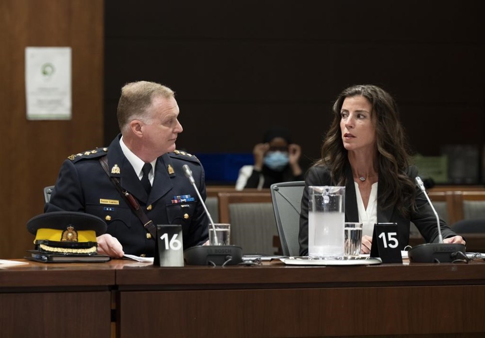 RCMP Chief Supt. Darren Campbell speaks with Director Strategic Communications Unit Lia Scanlan as they wait to appear before the Standing Committee on Public Safety and National Security, Tuesday, August 16, 2022 in Ottawa. The committee is looking into allegations of political interference in the 2020 Nova Scotia Mass murder investigation. THE CANADIAN PRESS/Adrian Wyld