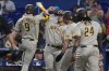 San Diego Padres' Jake Cronenworth (9) is congratulated by his teammates after hitting a grand slam in the first inning of a baseball game against the Miami Marlins, Wednesday, Aug. 17, 2022, in Miami. (AP Photo/Marta Lavandier)