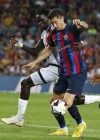 Barcelona's Robert Lewandowski, right, is held by Rayo's Pathe Ciss during a Spanish La Liga soccer match between Barcelona and Rayo Vallecano at the Camp Nou stadium in Barcelona, Spain, Saturday, Aug. 13, 2022. (AP Photo/Joan Monfort)