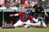 Detroit Tigers' Javier Baez scores past Cleveland Guardians catcher Austin Hedges on a ball hit by Harold Castro, while home plate umpire Lance Barksdale watches during the first inning of a baseball game Tuesday, Aug. 16, 2022, in Cleveland. (AP Photo/Ron Schwane)