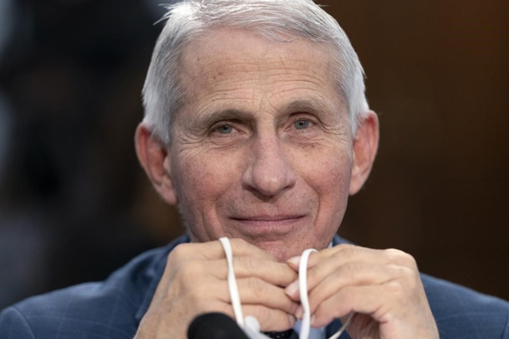 FILE - Dr. Anthony Fauci, Director of the National Institute of Allergy and Infectious Diseases, holds his face mask in his hands as he attends a House Committee on Appropriations subcommittee hearing on about the budget request for the National Institutes of Health, May 11, 2022, on Capitol Hill in Washington. Fauci, the nation's top infectious disease expert who became a household name, and the subject of partisan attacks, during the COVID-19 pandemic, announced Monday he will depart the federal government in December after more than 5 decades of service. (AP Photo/Jacquelyn Martin, File)