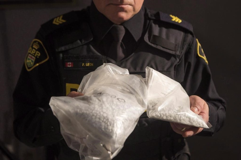 An OPP officer displays bags containing fentanyl as Ontario Provincial Police host a news conference in Vaughan, Ont., on February 23, 2017. Opioids have killed more people in Ontario in the second year of the pandemic compared to the first, but there was a drop in deaths in March, newly released data shows, giving the chief coroner some hope that trend continues. The deadly drugs continue to kill people at a much higher rate in the province's north compared to the south. And opioids are also killing young people, specifically men aged 25 to 44, more than other age groups, the data shows. THE CANADIAN PRESS/Chris Young