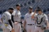 Chicago White Sox starting pitcher Michael Kopech, second from left, stands on the mound with teammates before coming out of the game during the first inning of a baseball game against the Kansas City Royals Monday, Aug. 22, 2022, in Kansas City, Mo. (AP Photo/Charlie Riedel)