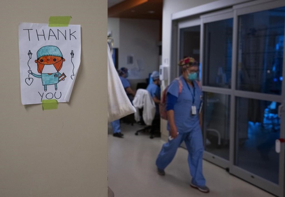 A health-care worker walks past a thank you sign in the intensive care unit at the Humber River Hospital during the COVID-19 pandemic in Toronto on January 25, 2022. A new survey suggests there is a significant decrease in the well-being of physicians across Canada as many doctors say their mental health is worse now than before the COVID-19 pandemic. The Canadian Medical Association's new National Physician Health Survey indicates 53 per cent of respondents report symptoms of burnout including emotional exhaustion and depersonalization. THE CANADIAN PRESS/Nathan Denette