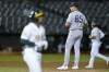 New York Yankees relief pitcher Greg Weissert (85) looks toward home plate after walking Oakland Athletics' Tony Kemp, foreground, to load the bases during the seventh inning of a baseball game in Oakland, Calif., Thursday, Aug. 25, 2022. (AP Photo/Godofredo A. Vásquez)