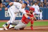 Los Angeles Angels' second baseman David Fletcher (22) slides safely into third base ahead of a tag by Toronto Blue Jays’ third baseman Matt Chapman in first inning American League baseball action in Toronto on Friday, August 26, 2022. THE CANADIAN PRESS/Jon Blacker