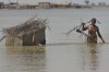 A flood-affected family use metal-trunk to salvage belongings from their nearby flooded home caused by heavy rain, in Qambar Shahdadkot district of Sindh Province, of Pakistan, Friday, Sep. 2, 2022. Planes carrying fresh supplies are surging across a humanitarian air bridge to flood-ravaged Pakistan as the death toll surged past 1,200, officials said Friday, with families and children at special risk of disease and homelessness. (AP Photo/Fareed Khan)