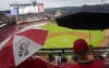 Fans take cover during a rain delay prior to a baseball game between the Colorado Rockies and the Cincinnati Reds Saturday, Sept. 3, 2022, in Cincinnati. (AP Photo/Jeff Dean)
