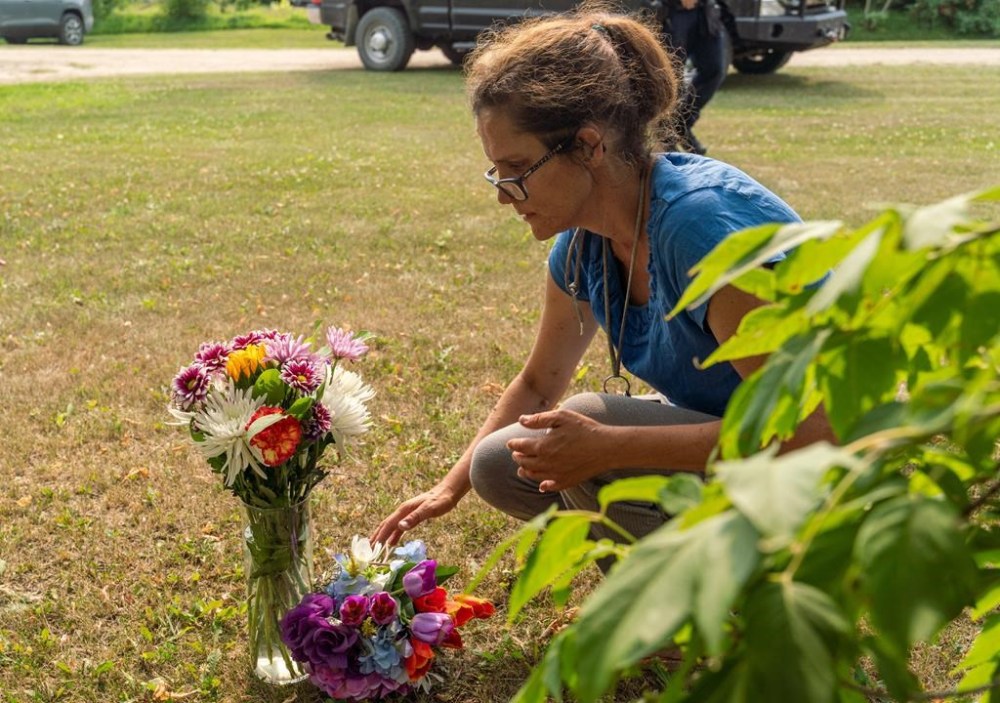 Ruby Works places flowers at the home of a victim who has been identified by residents as Wes Petterson in Weldon, Sask., on Monday, Sept. 5, 2022. Works said that the 77-years-old victim was like an uncle to her. Saskatchewan RCMP say arrest warrants have been issued for two suspects in the deadly stabbing rampage. THE CANADIAN PRESS/Heywood Yu