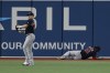 Boston Red Sox center fielder Enrique Hernandez, left, throws the ball as teammate Franchy Cordero, right, lies on the field during the fifth inning of a baseball game against the Tampa Bay Rays, Monday, Sept. 5, 2022, in St. Petersburg, Fla. (AP Photo/Scott Audette)
