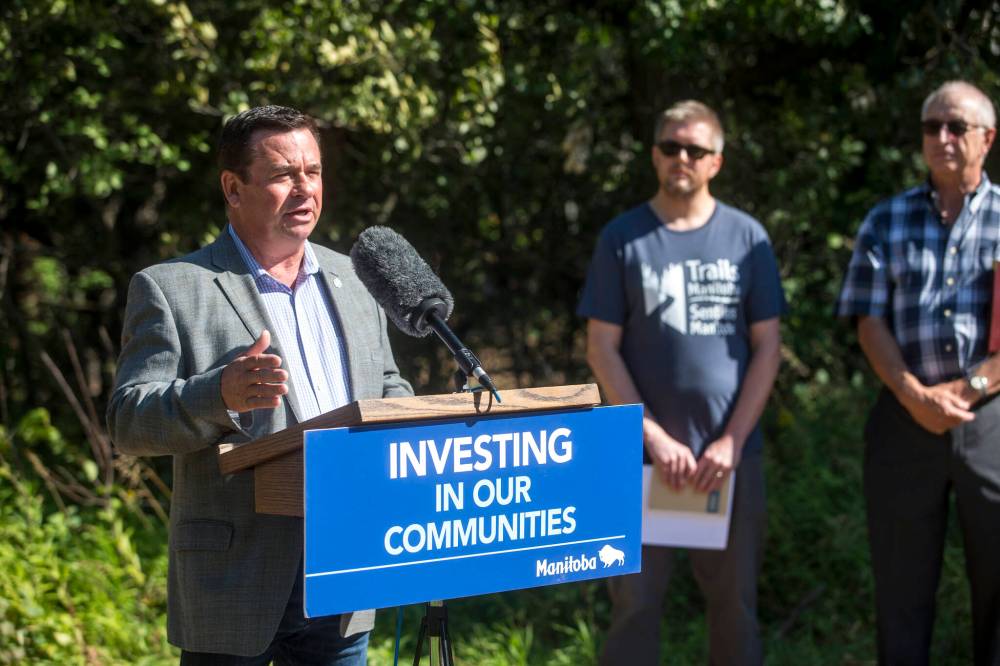 MIKAELA MACKENZIE / WINNIPEG FREE PRESS
Environment, Climate and Parks Minister Jeff Wharton speaks at the announcement of grants for 30 trail improvement projects across the province Friday at Assiniboine Forest with Erik Dickson, president of Trails Manitoba (centre), and Jack Wilson, vice-president of the Charleswood Rotary Club.