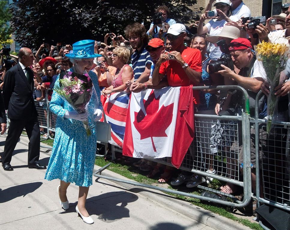 Queen Elizabeth II, right, and Prince Philip the Duke of Edinburgh, left, walk near a crowd of people after attending mass at the Cathedral Church of St.James in Toronto on Sunday, July 4, 2010. THE CANADIAN PRESS/Nathan Denette