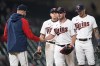 Minnesota Twins starting pitcher Dylan Bundy, second from right,, hands the ball to manager Rocco Baldelli, left, while being pulled from a baseball game during the fifth inning against the Cleveland Guardians, Friday, Sept. 9, 2022, in Minneapolis. (AP Photo/Abbie Parr)