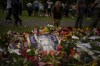 Flowers and candles for Queen Elizabeth II are seen at the gates outside Buckingham Palace in London, Saturday, Sept. 10, 2022. Queen Elizabeth II, Britain's longest-reigning monarch and a rock of stability across much of a turbulent century, died Thursday Sept. 8, 2022, after 70 years on the throne. She was 96. (AP Photo/Emilio Morenatti)