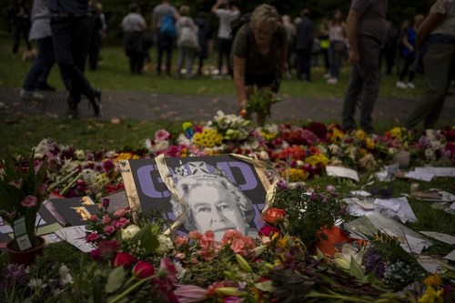 Flowers and candles for Queen Elizabeth II are seen at the gates outside Buckingham Palace in London, Saturday, Sept. 10, 2022. Queen Elizabeth II, Britain's longest-reigning monarch and a rock of stability across much of a turbulent century, died Thursday Sept. 8, 2022, after 70 years on the throne. She was 96. (AP Photo/Emilio Morenatti)