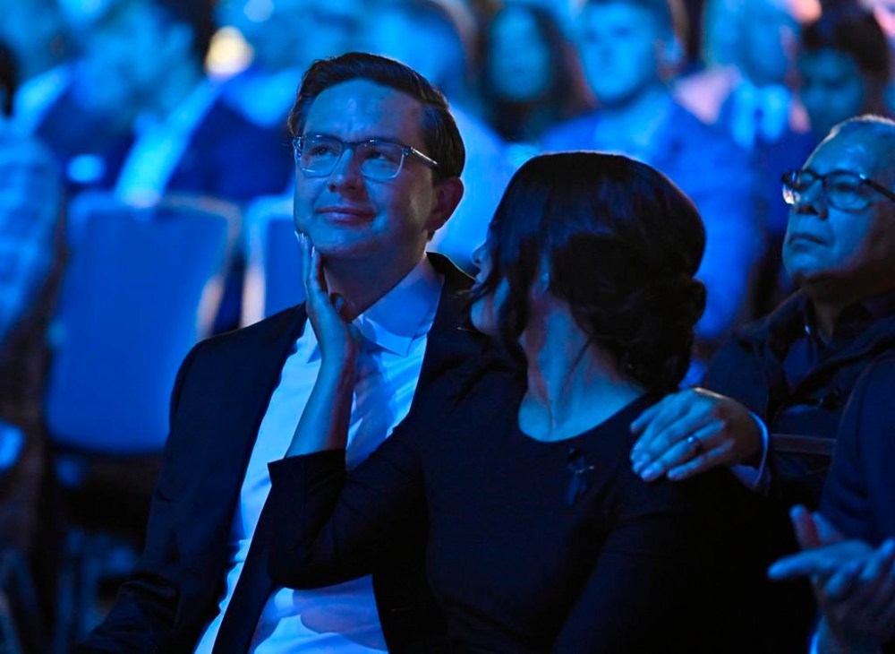 Anaida Poilievre, wife of Conservative Party leadership candidate Pierre Poilievre, touches his chin as they listen to speeches at the Conservative Party of Canada leadership vote, in Ottawa, on Saturday, Sept. 10, 2022. THE CANADIAN PRESS/Justin Tang
