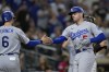Los Angeles Dodgers' Freddie Freeman, right, is greeted by teammate Trea Turner after hitting a two-run home run during the seventh inning of a baseball game against the San Diego Padres, Saturday, Sept. 10, 2022, in San Diego. (AP Photo/Gregory Bull)