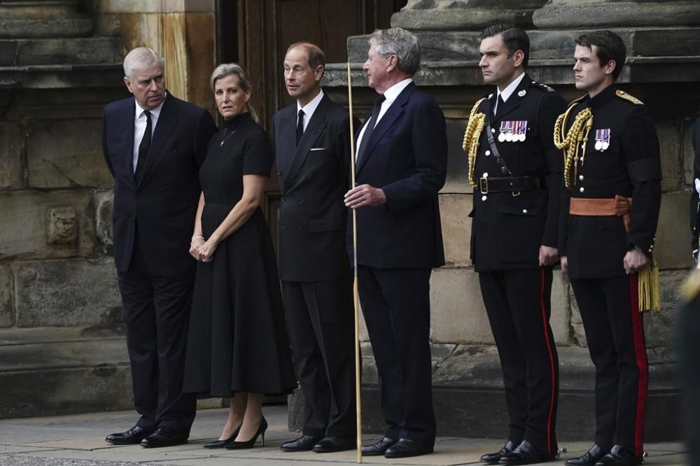Britain's Prince Andrew, left, Sophie, Countess of Wessex, and Prince Edward, third left, await the arrival of the hearse carrying the coffin of Queen Elizabeth II, draped with the Royal Standard of Scotland, as it completes its journey from Balmoral to the Palace of Holyroodhouse in Edinburgh, Scotland, Sunday Sept. 11, 2022. (Aaron Chown/Pool via AP)