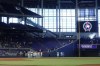 Fans and players take a moment of silence to mark the 9/11 attacks, before the start of a baseball game between the Miami Marlins and the New York Mets, Sunday, Sept. 11, 2022, in Miami. (AP Photo/Wilfredo Lee)