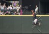 Atlanta Braves centerfielder Michael Harris II climbs the outfield wall in an attempt to get to a home run ball hit by Seattle Mariners' Eugenio Suarez during the fifth inning of a baseball game, Sunday, Sept. 11, 2022, in Seattle. (AP Photo/Stephen Brashear)