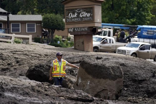 Paul Burgess, with the California Geological Survey, examines the damage in the aftermath of a mudslide Tuesday, Sept. 13, 2022, in Oak Glen, Calif. Cleanup efforts and damage assessments are underway east of Los Angeles after heavy rains unleashed mudslides in a mountain area scorched by a wildfire two years ago. (AP Photo/Marcio Jose Sanchez)