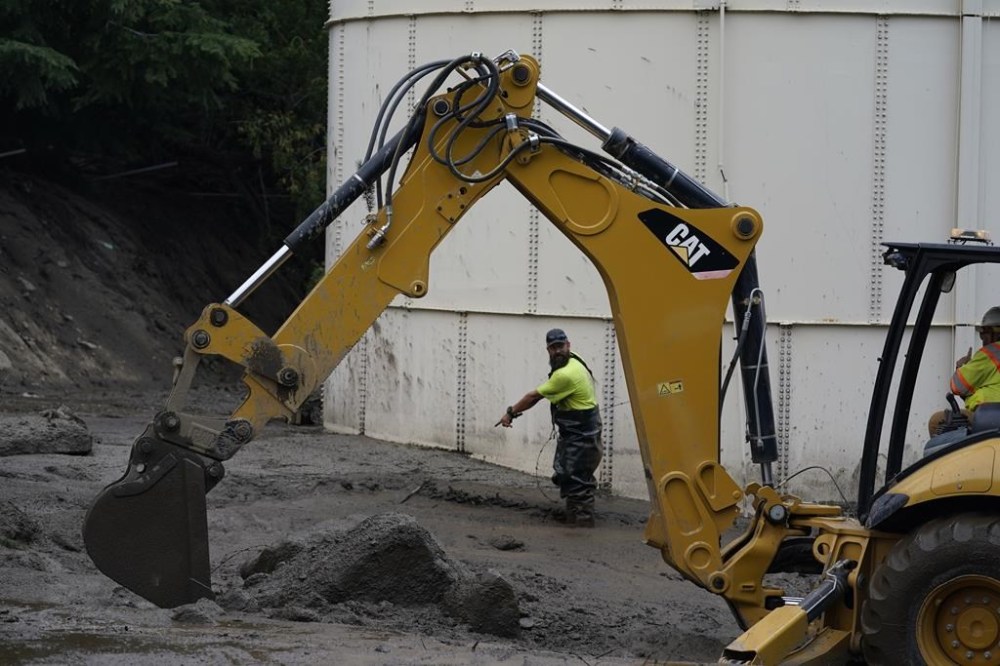 Workers with the Yucaipa Valley Water District work on repairing a reservoir used as a drinking source in the aftermath of a mudslide, Tuesday, Sept. 13, 2022, in Oak Glen, Calif. (AP Photo/Marcio Jose Sanchez)